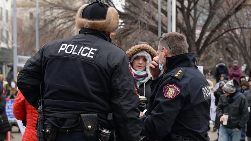 Des policiers de Calgary s'adressent à des manifestants contre les restrictions sanitaires en décembre 2020.