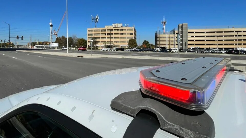 Le toit d'une autopatrouille avec une route et des bâtiments en arrière-plan.