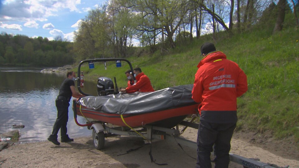 Des pompiers de la Ville de Sherbrooke préparent leur bateau de sauvetage.