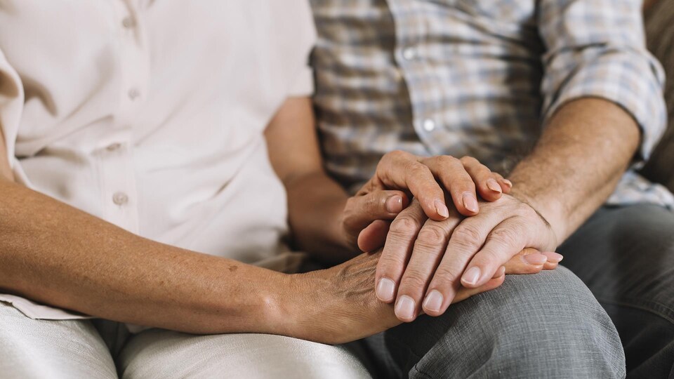 Gros plan d'une paire de mains d'une personne qui tient une main d'autre autre personne.