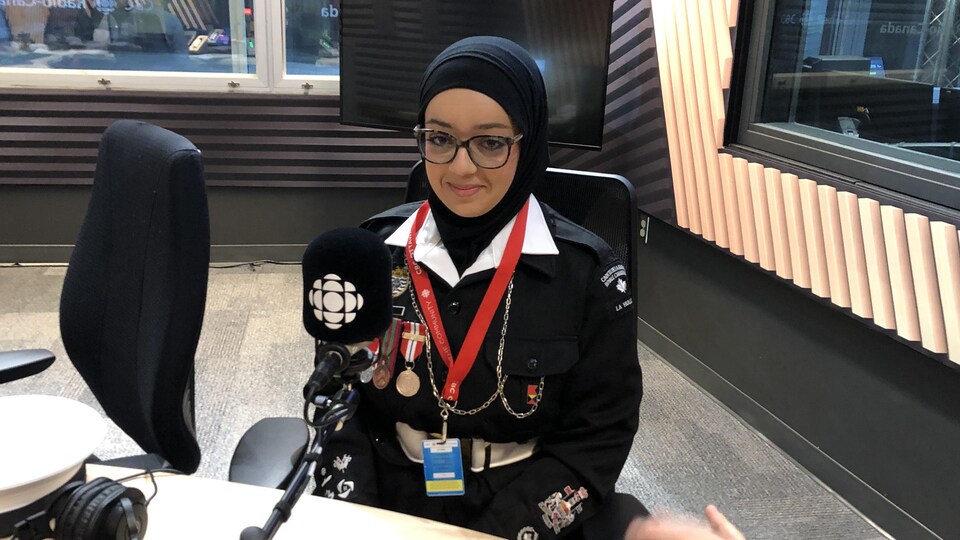 Une jeune cadette de la Marine royale canadienne en entrevue dans un studio de radio.