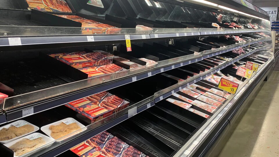Une étagère d'épicerie presque vide.