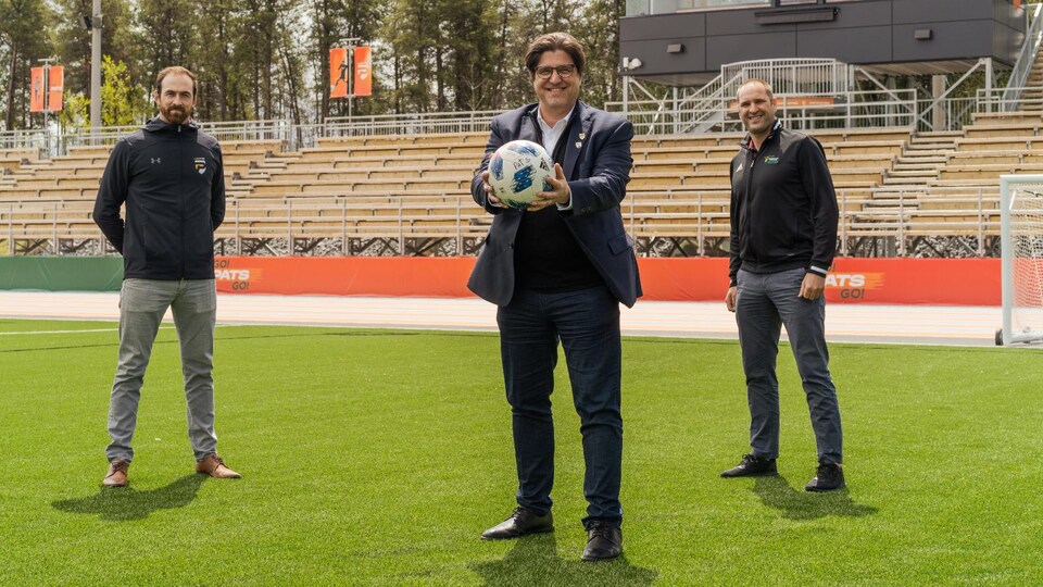 L'entraîneur de la formation masculine de soccer des Patriotes, Shany Black, le recteur de l'UQTR, Christian Blanchette, et le directeur adjoint du Service de l'activité physique et sportive de l’UQTR, Simon Bélanger sur le nouveau terrain de soccer synthétique de l'université.