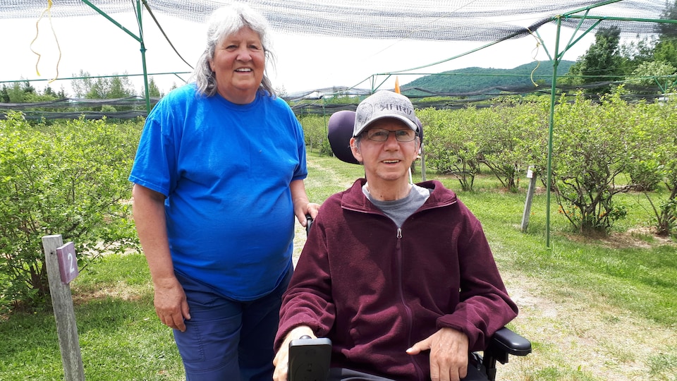 Carmen et Gérald Auger dans un champ de fruits. 