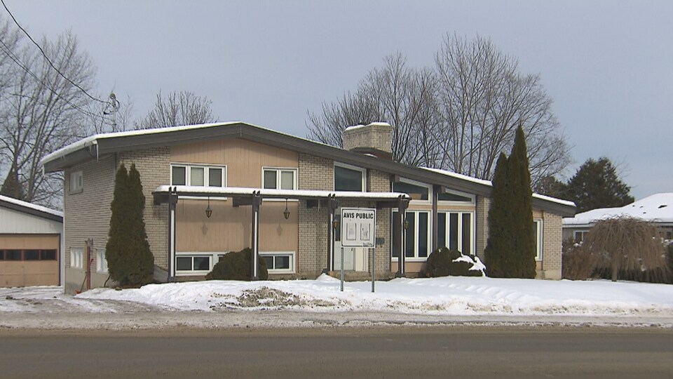 Une maison avec une pancarte d'avis public.