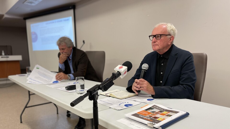 Robert Benoît parle à un micro.