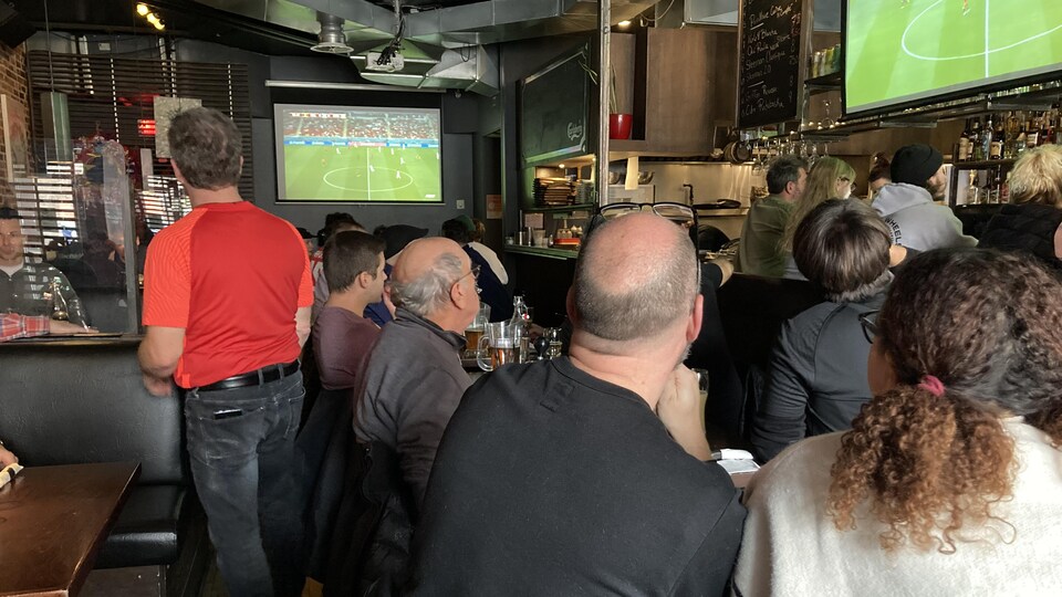 Des gens regardent un match de soccer. 