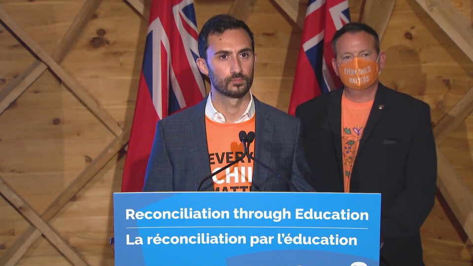 Les deux ministres en conférence de presse. Tous deux portent des chemises orange.