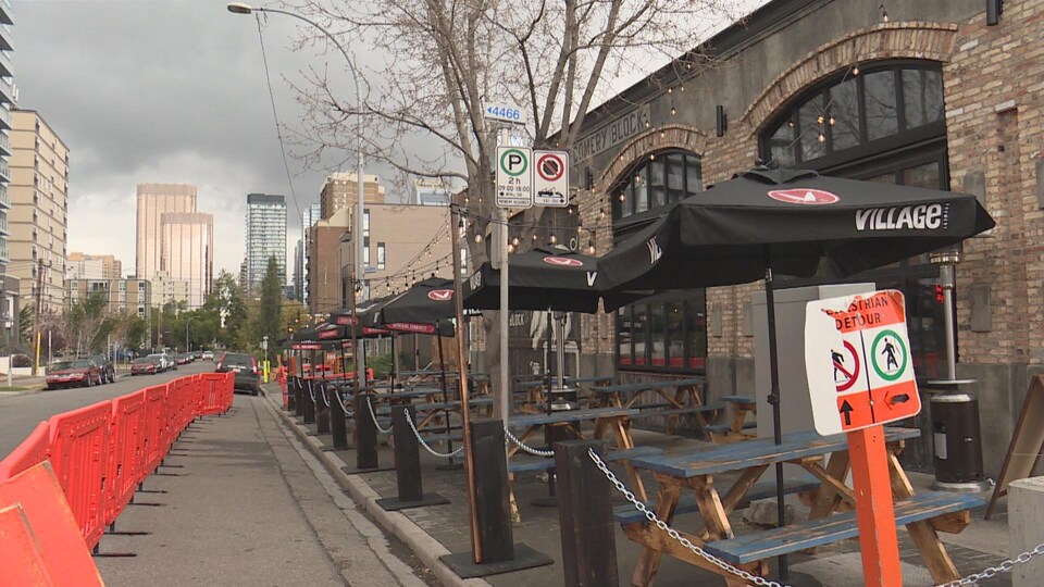 Des tables de pique-nique ont été installées sur un trottoir.