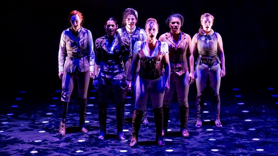 Six femmes se tiennent debout et chantent.