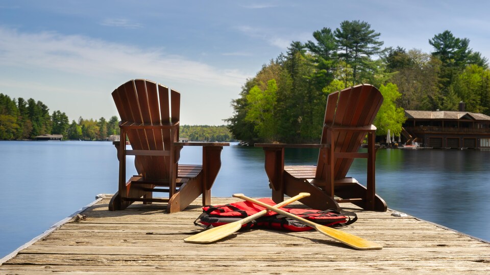Deux chaises sur un quai au bord d'un lac.