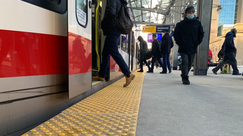 Des usagers entrent dans le train à Calgary.