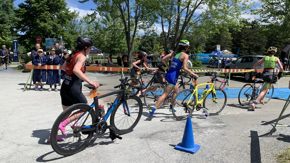Des triathloniens courent à côté de leur vélo dans le parc Blanchard de Sherbrooke.