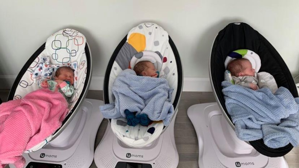 Trois bébés couchés dans leur chaise berçante.