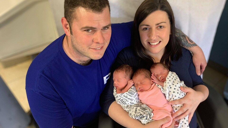 Denis et Rachel Comeau, qui elle tient trois bébés dans ses bras.