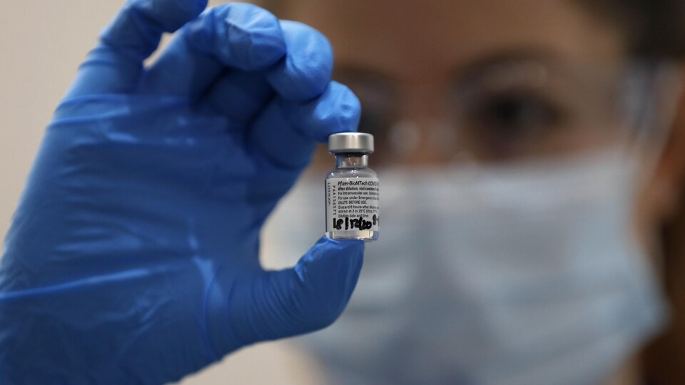 Une infirmière tient une fiole contenant le vaccin Pfizer/BioNTech.