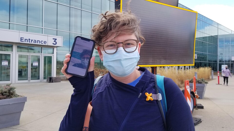 Tara Beck devant une clinique de vaccination présente son autoportrait.