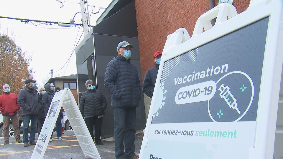 File de personnes attendant devant le centre de vaccination.