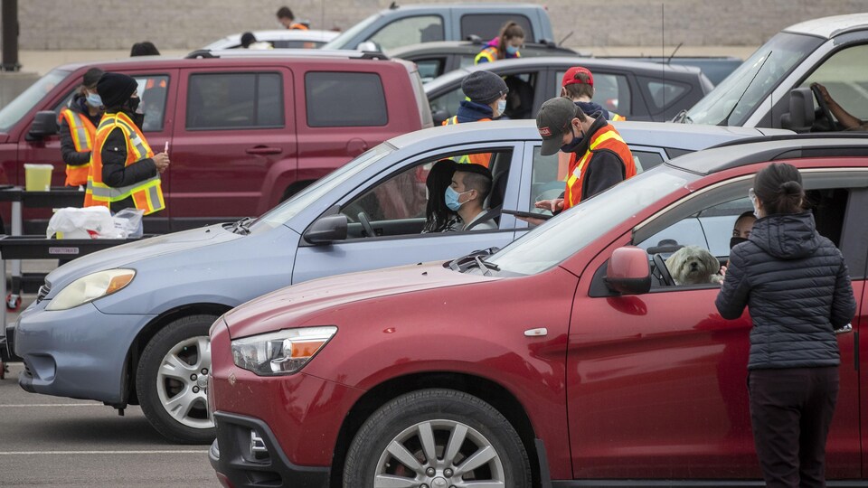 Des personnes attendent dans leur véhicule pour se faire vacciner.