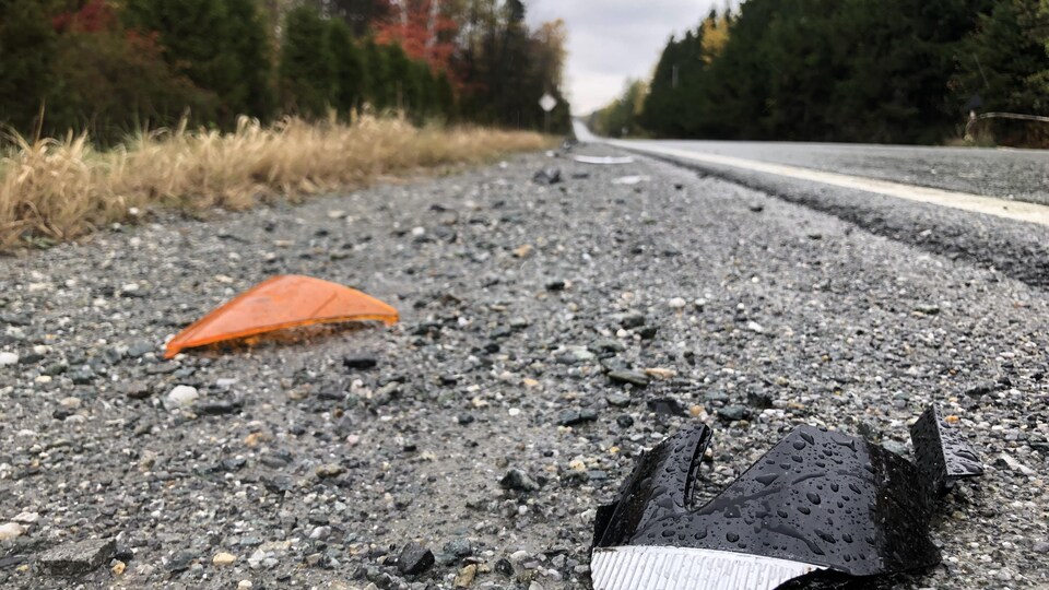 Des débris de la voiture gisent au sol.