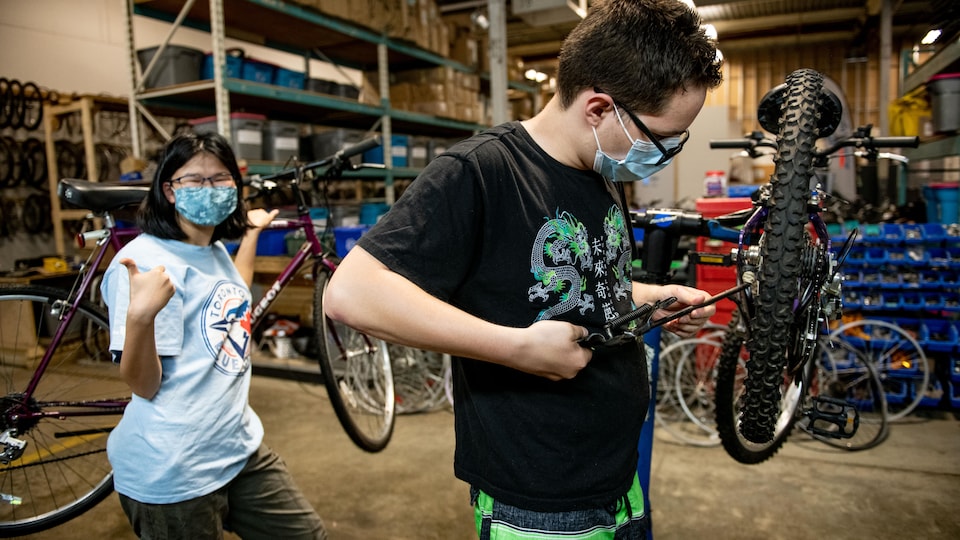 Deux jeunes travaillant sur un vélo