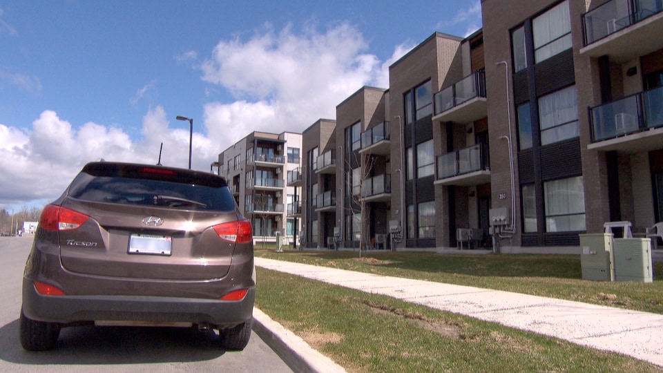 A car registered in Ontario in front of an apartment building.