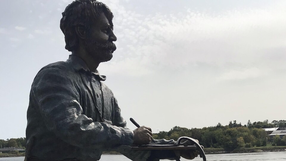 Une statue de William Francis Ganong à l'extérieur, le long de l'eau.