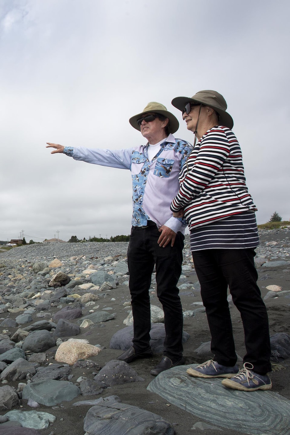 Deux personnes sur une plage regarde au loin.