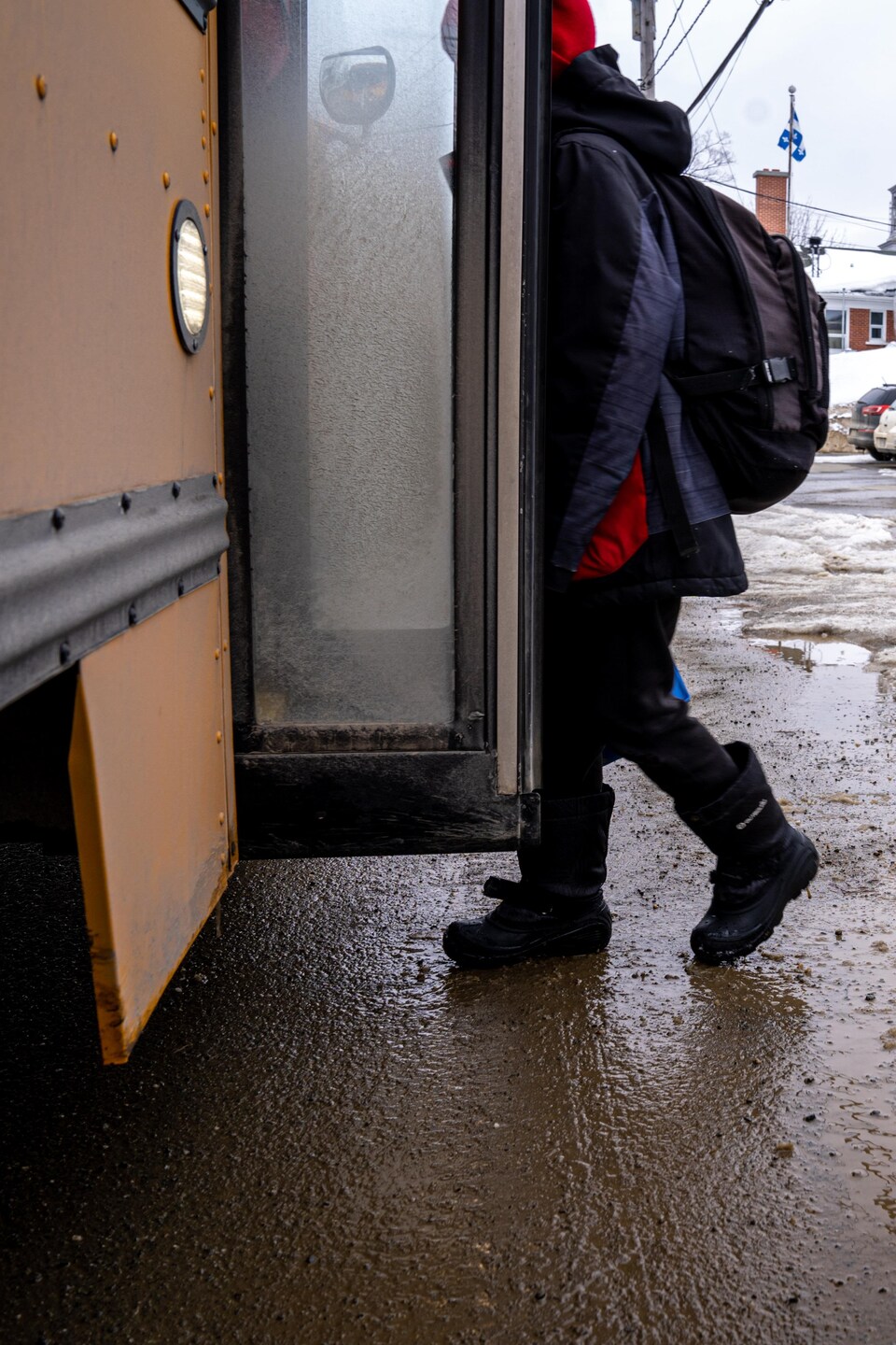 Un enfant qui entre dans un autobus. 