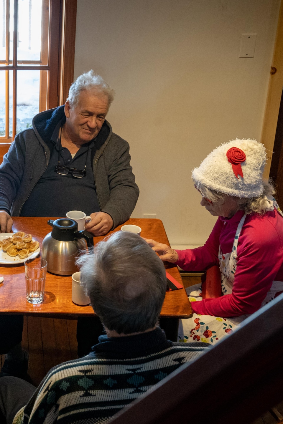 Des aînés assis à la table d'un café qui discutent.