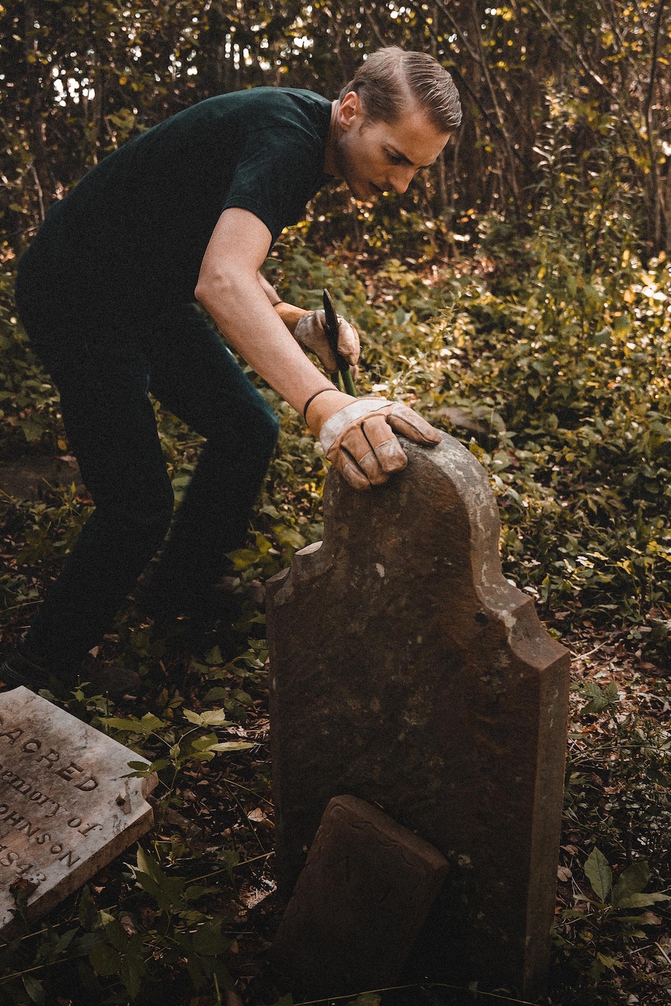 Steve Skafte regarde une pierre tombale dans un cimetière.