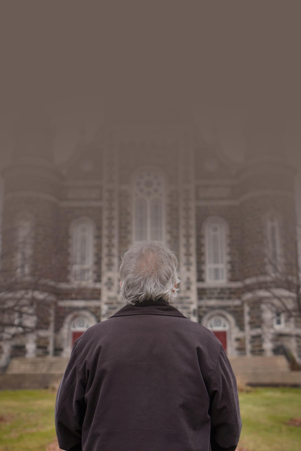 Un homme se tient debout devant la façade d'une église.