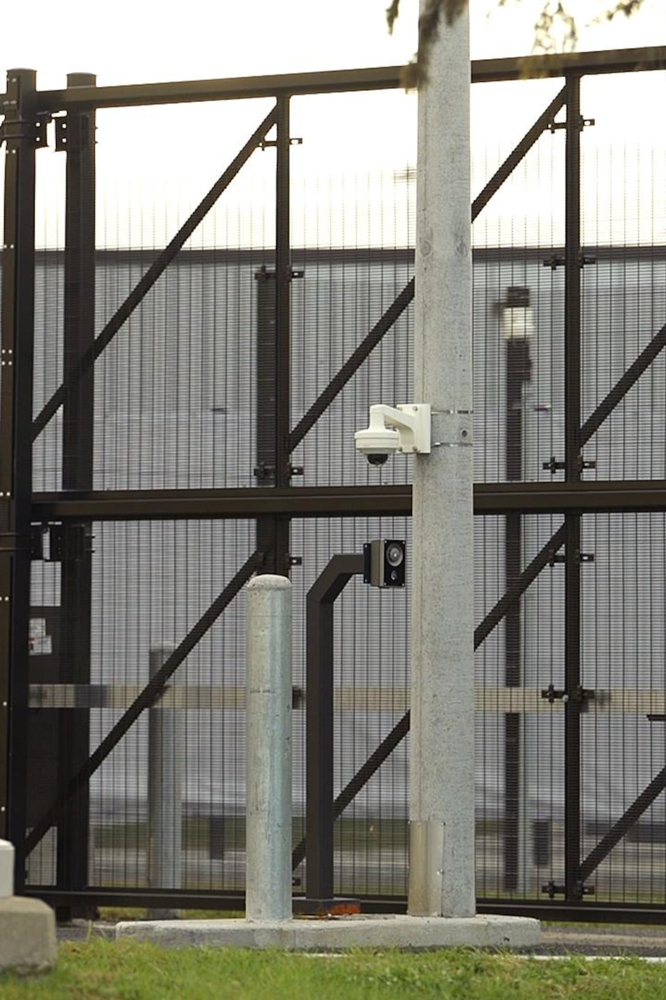 La devanture d'un centre de détention entouré d'une grande clôture.