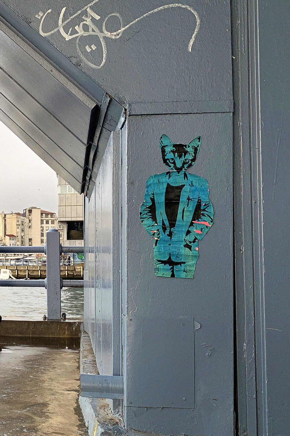 Une œuvre qui représente une personne avec une tête de chat est collée sur une paroi du pont de Galata à Istanbul.