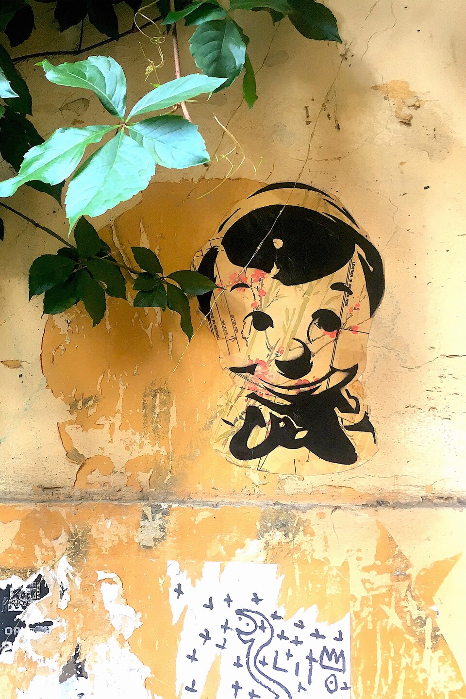 Une œuvre qui représente le personnage de Pinocchio est collée sur un mur.