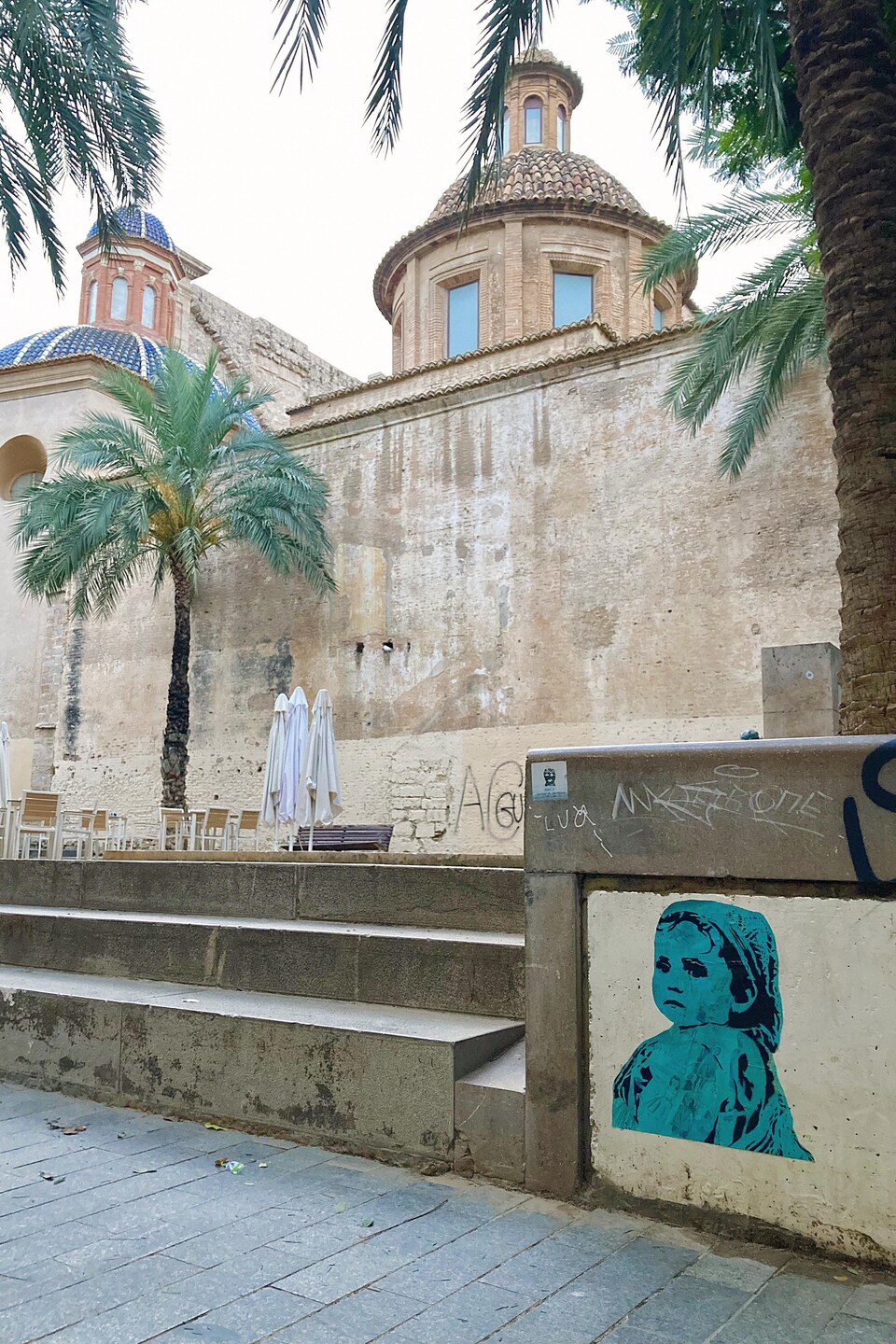 Une œuvre qui représente un enfant est collée sur un mur près d'un édifice à Valence.