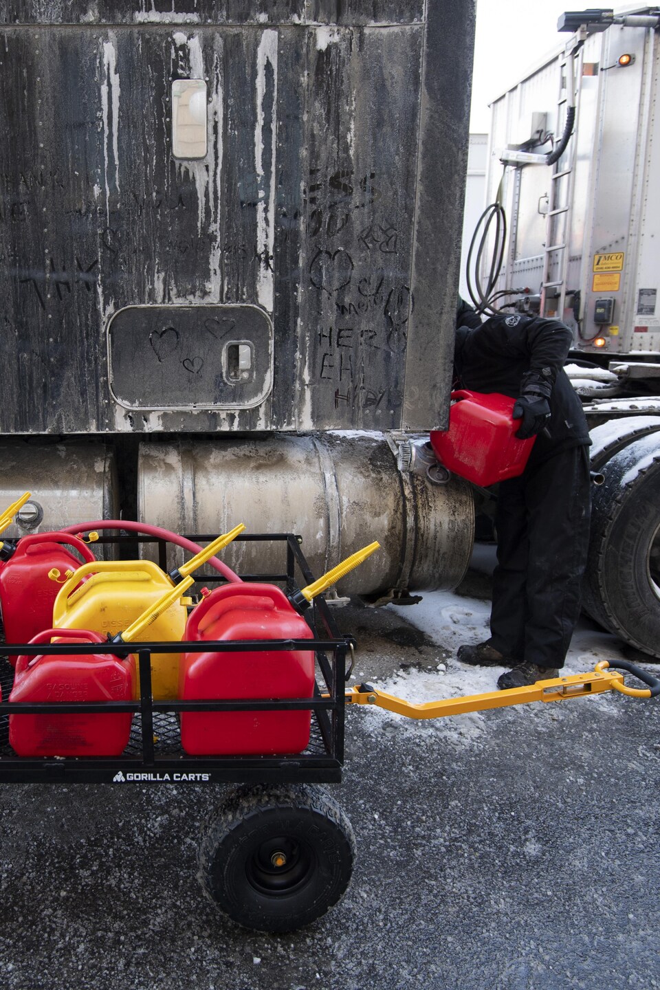 Une personne remplit un camion semi-remorque d'essence.