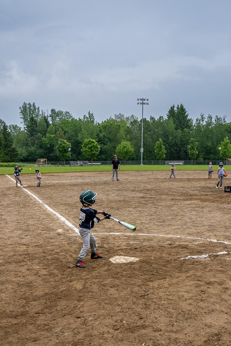Des petits joueurs sur un terrain de baseball.