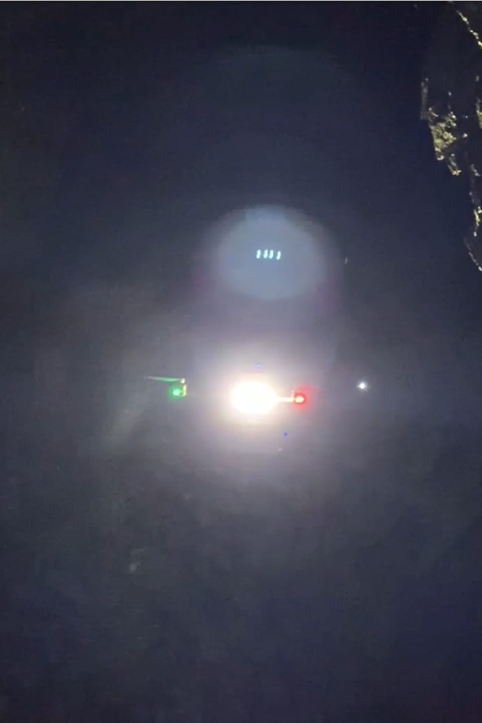 Les lumières du drone en vol éclairent les parois rocheuses de la mine.