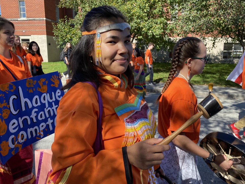 Une jeune femme autochtone participe à une manifestation. 