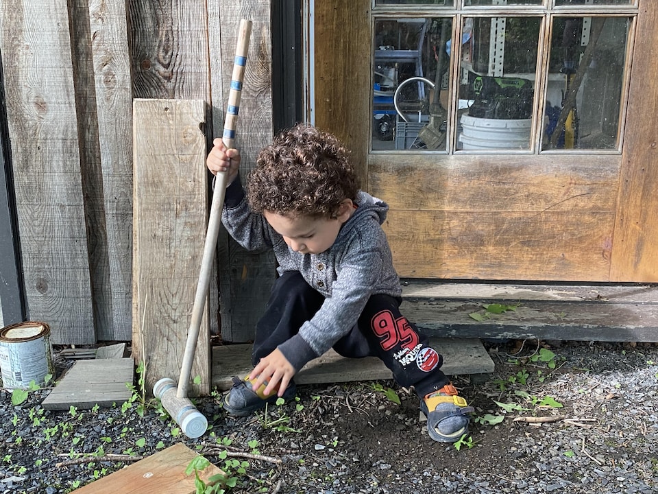 The boy is playing with a croquet stick. 