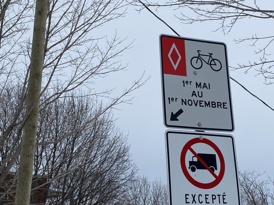 Un panneau qui indique que la piste cyclable est ouverte du 1er mai au 1er novembre. 