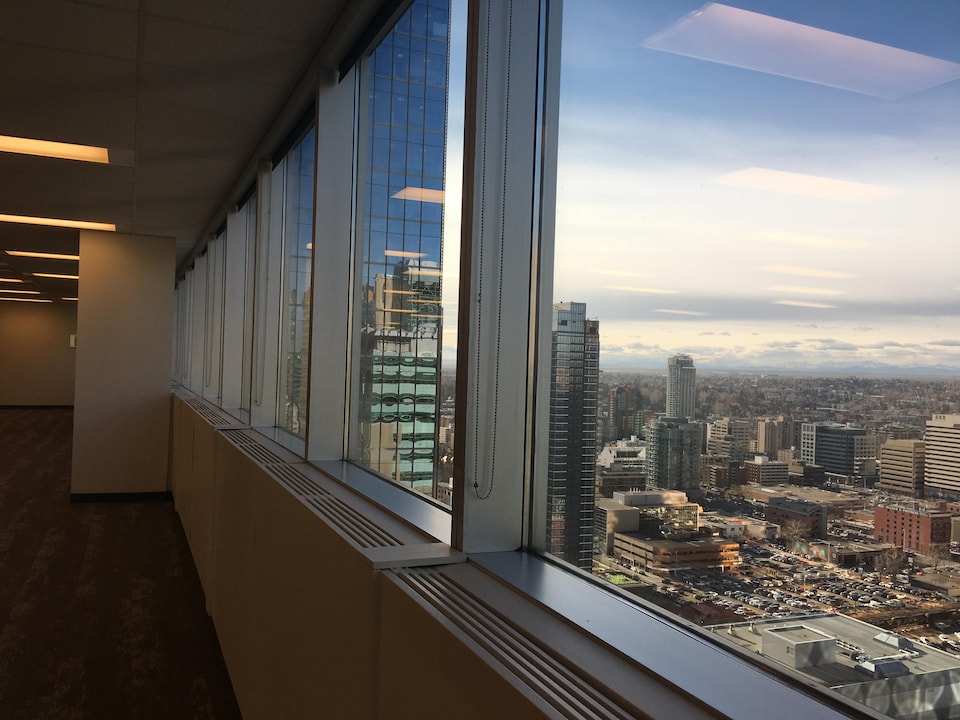 La fenêtre d'un bureau vide donne une vue sur le centre-ville de Calgary. 
