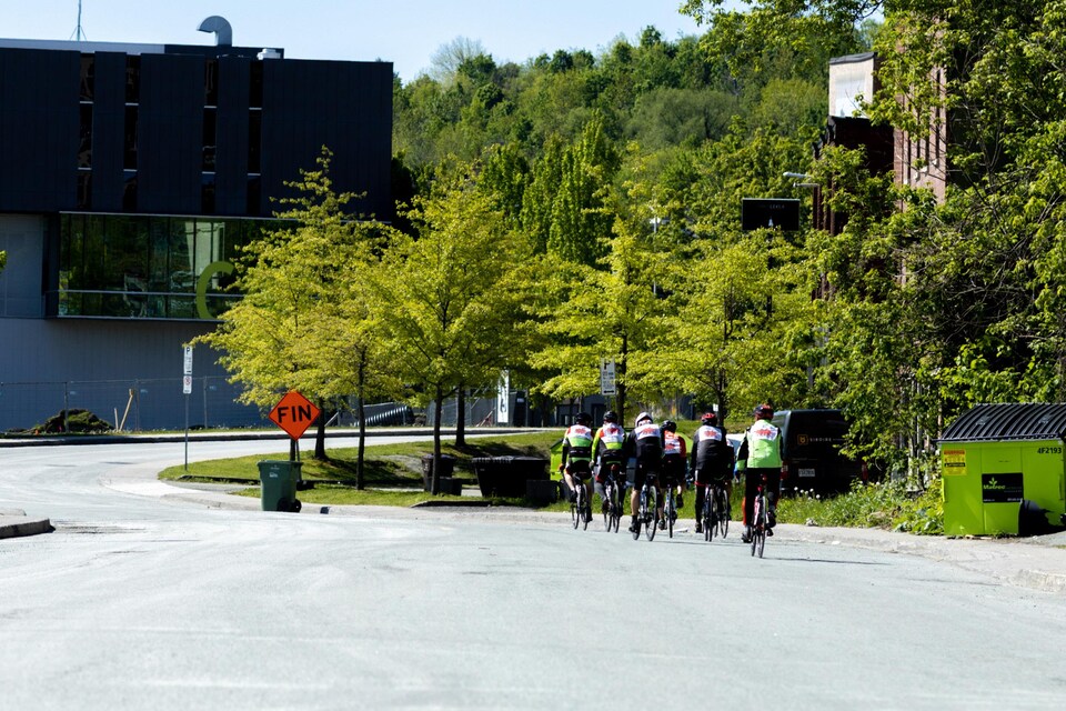 Sept cyclistes roulent sur la route. 