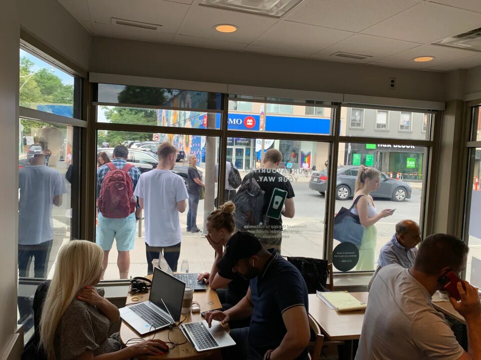 Des gens concentrés sur leur ordinateur dans un café.