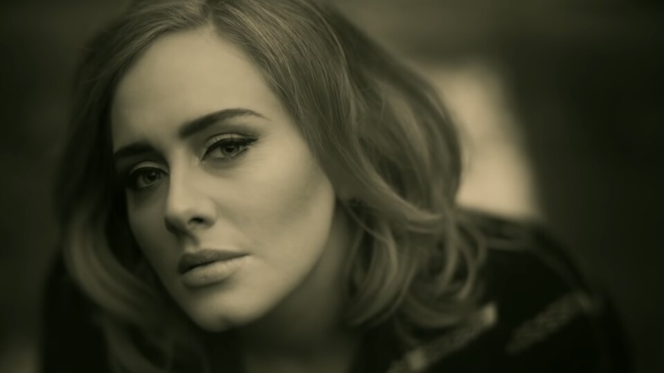 Un gros plan d'Adele la montre regardant la caméra.