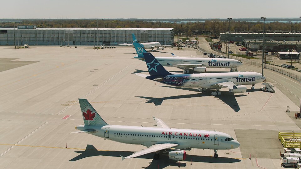 Deux avions d'Air Transat et un d'Air Canada garés sur le tarmac.