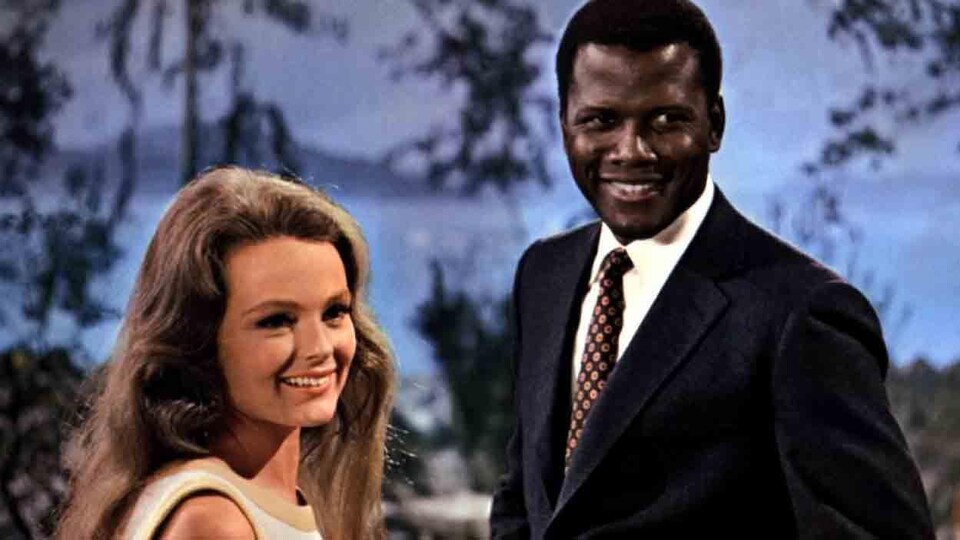 Une jeune femme blanche et un jeune homme noir souriants.