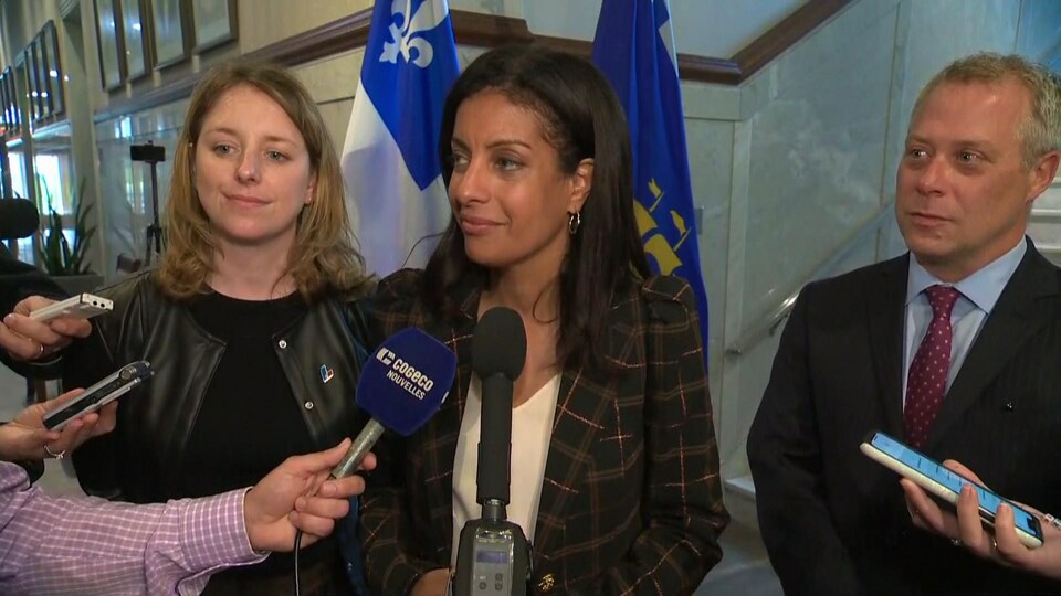 Dominique Anglade dans une mêlée de presse avec Julie White et Charles Robert à ses côtés.