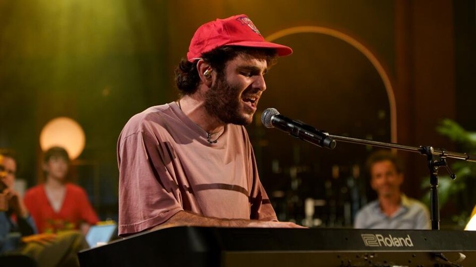 Etienne Coppée qui chante en s'accompagnant aux claviers.